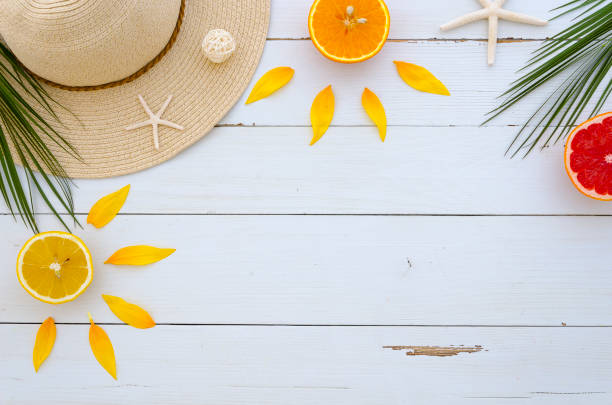 Corner frame arranged by a summer hat, tropical palm leaves, sea stars, fresh citrus fruits, seastones on white wooden background. Flat lay, top view, copy space mock up. Ideal for lettering and other. marco de esquina dispuestos por un sombrero de verano, hojas de palmeras tropicales, cítricos frescos, seastones sobre fondo blanco de madera. endecha plana, vista superior, copia falsa del espacio para arriba. ideal para rotulación y otros.