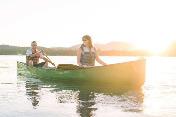 istock Senior couple canoeing together around a forested lake. 1016287102
