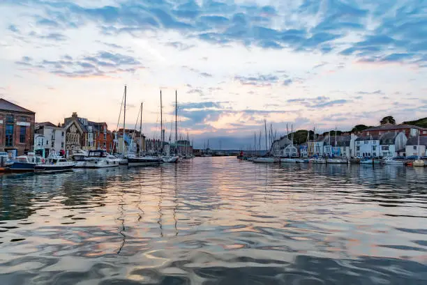 Calm waters at Weymouth Harbour at dawn sunrise
