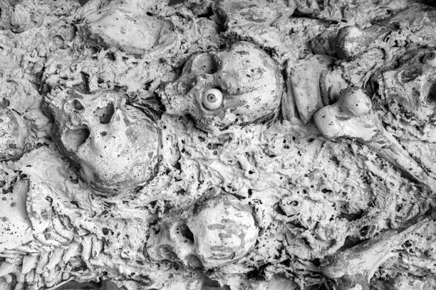 istock Human skulls and bodies fixed in the stone wall 1016289714