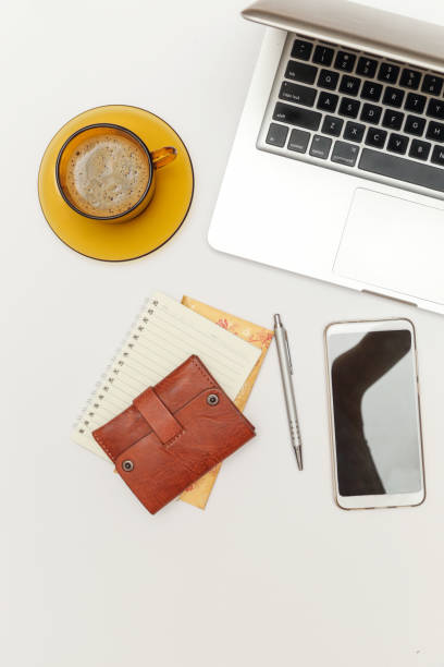 Office desk workspace. Top view. Wallet, laptop, phone and a cup of coffee