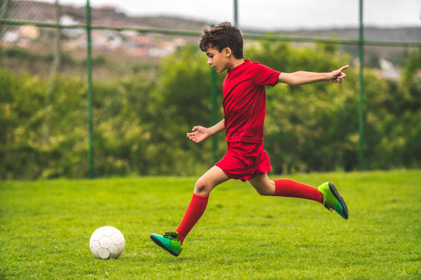 chłopiec przygotowuje się do kopnięcia piłki - soccer shoe soccer player kicking soccer field zdjęcia i obrazy z banku zdjęć