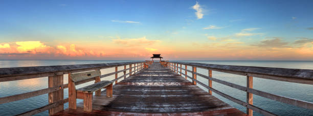 temprana salida del sol sobre el muelle de nápoles en el golfo la costa de nápoles, florida - florida naples florida pier beach fotografías e imágenes de stock