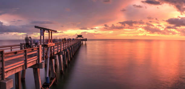 color rosa y púrpura puesta de sol sobre el muelle de nápoles - florida naples florida pier beach fotografías e imágenes de stock