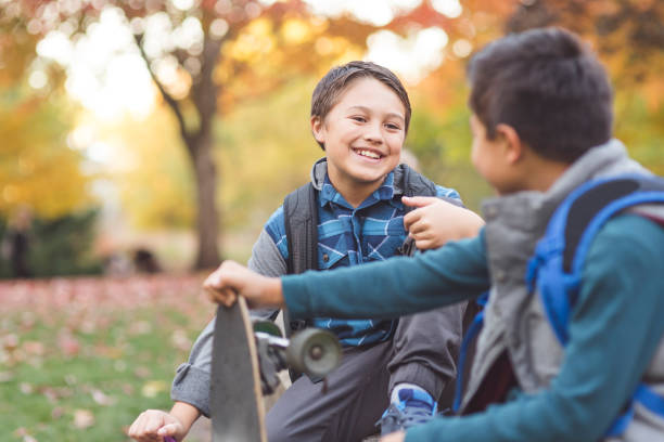 istock Two elementary age brothers hanging out at the park together 1016345780