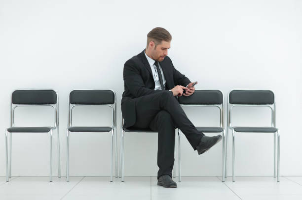 istock businessman with mobile sitting in the office hallway 1016351122