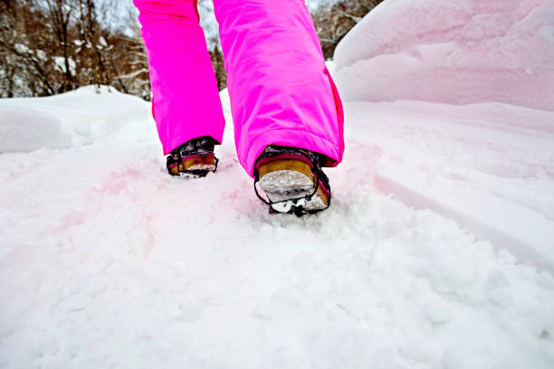Woman leg walking on snowy road.