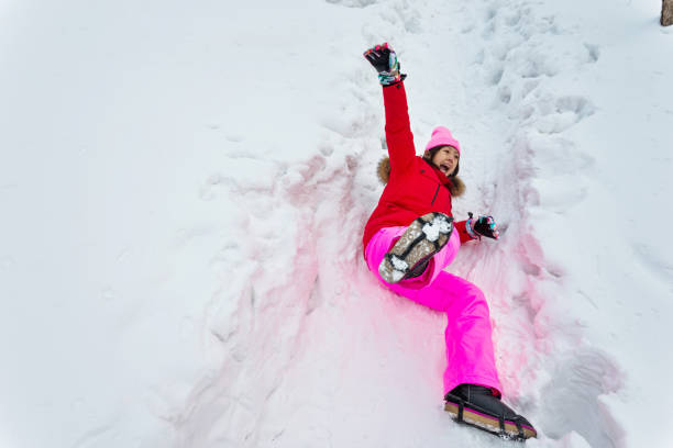 Woman falling down on the snow road.