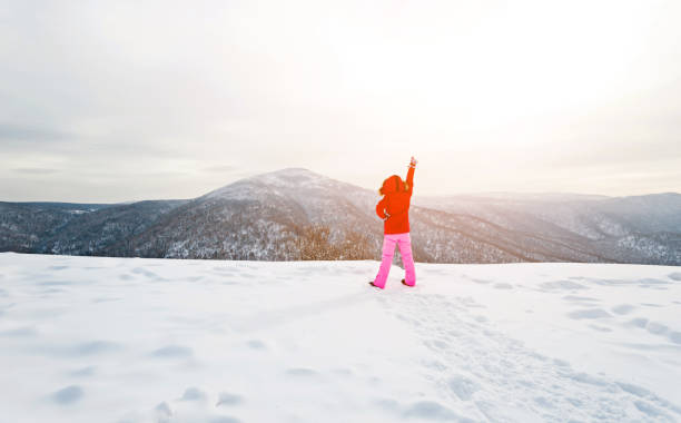 Woman hiker on mountain top in winter.