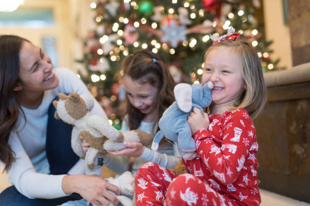 istock Mom laughs with her two daughters in front of the Christmas tree 1016392884