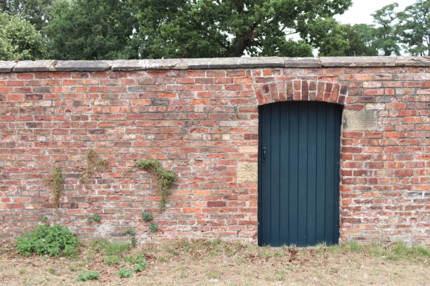 Garden wall and gate Red brick garden wall and painted wooden gate walled garden stock pictures, royalty-free photos & images