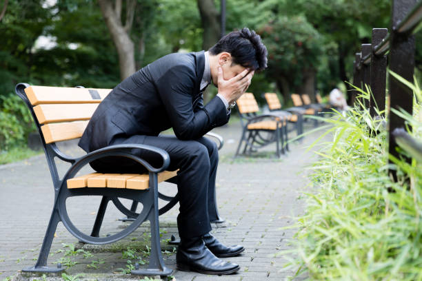portrait of young asian businessman in park - hopelessness imagens e fotografias de stock