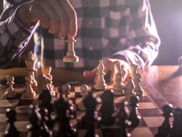 istock young male grandmaster hand making next move playing chess in dark place on a tournament 1016403564