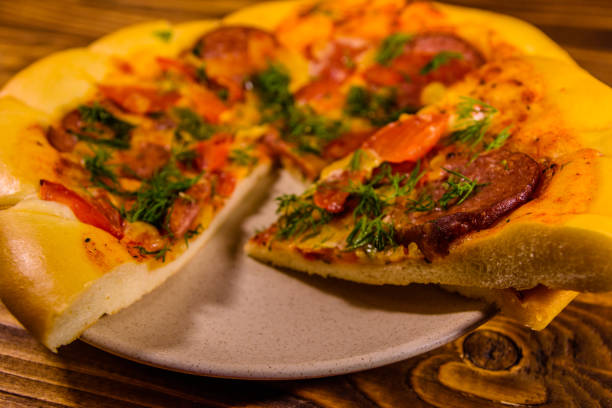 istock Ceramic plate with sliced homemade pizza on a wooden table 1016405826