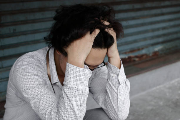 istock Tired overworked young Asian business manin depression with hands on forehead 1016449430