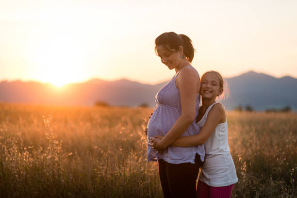 istock Daughter hugging her pregnant mother from behind 1016457010