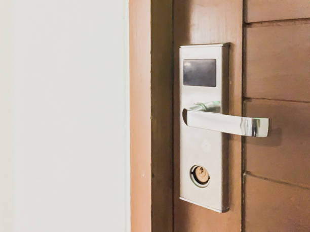 istock Modern door handle with security system electronic lock the hotel room door. Modern style door handle on natural wooden door chain hasp of the hotel. Close-up of the lock with your keys 1016459540