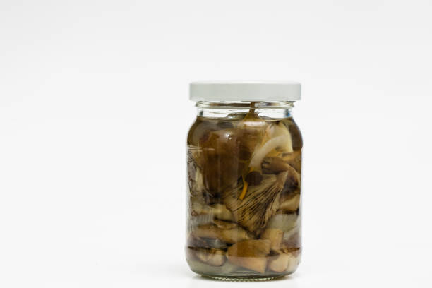 Vegetables in jars prepared for the winter. Tasty preserves on a white kitchen table. White background.