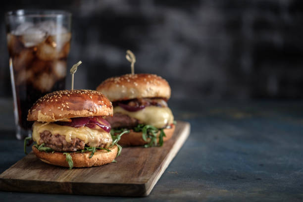 hausgemachte leckere hamburger mit rindfleisch, käse und karamellisierten zwiebeln. speiselokal, fast-food. exemplar - burger stock-fotos und bilder
