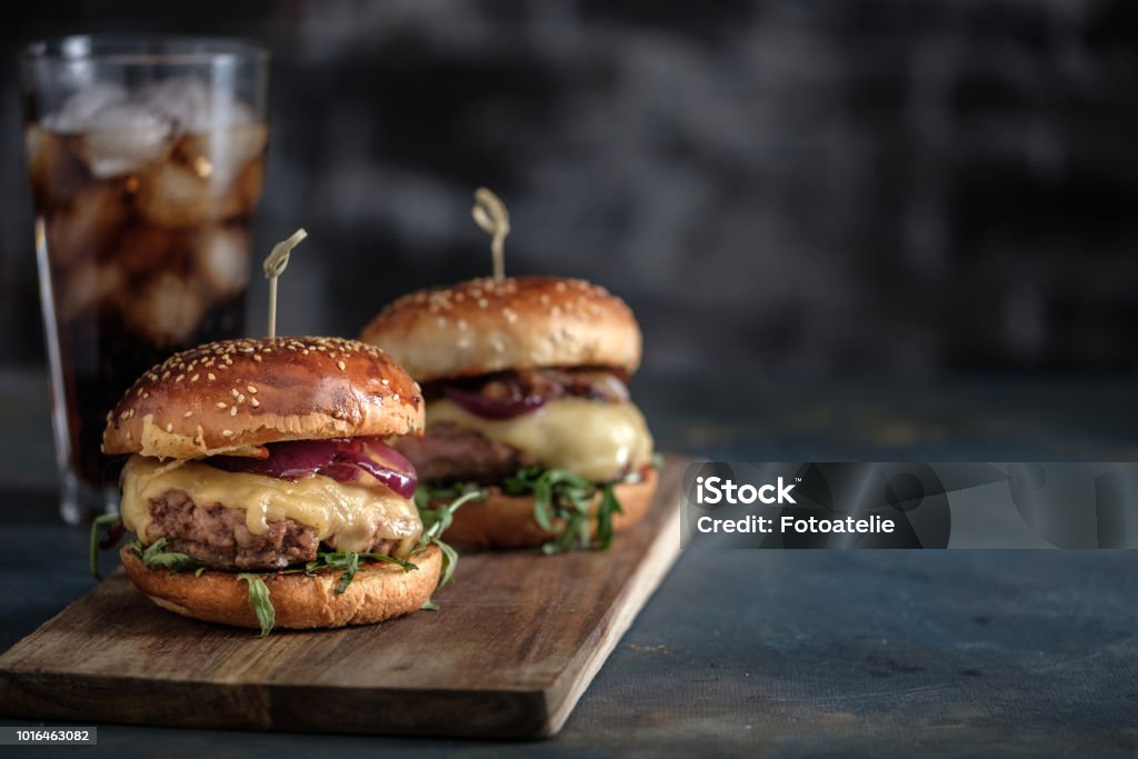 Hamburger gustoso fatto in casa con manzo, formaggio e cipolle caramellate. Cibo di strada, fast food. Spazio di copia - Foto stock royalty-free di Hamburger