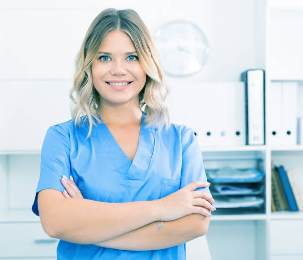 istock Friendly girl in doctor's uniform smiling at office 1016468060