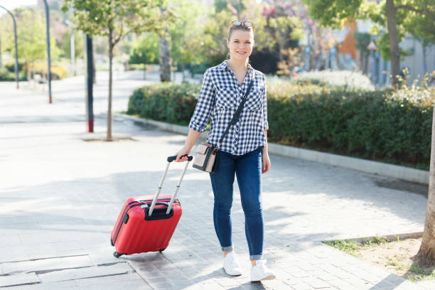 istock Girl walking around city with suitcase 1016468308