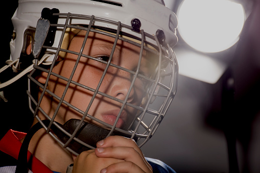 Niño en un casco de hockey, sesión fotográfica. Un muchacho en un casco de hockey photo