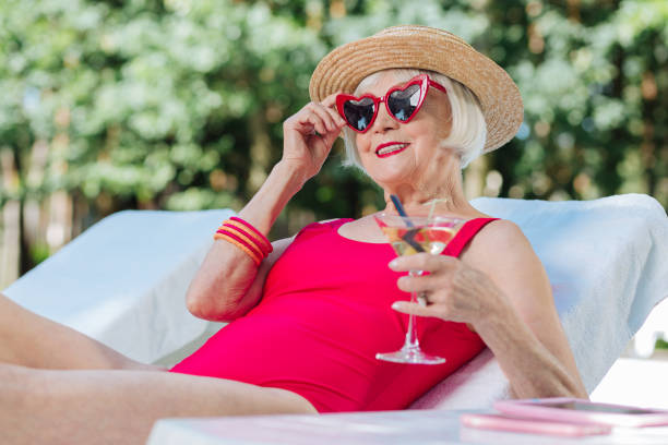 istock Mature woman feeling happy while having rest near pool 1016470712