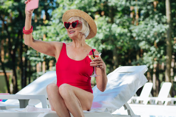 istock Modern beaming retired woman making selfie in swimming suit 1016473938