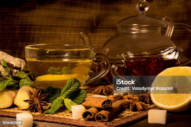 Lemon Tea With Transparent Mug And Teapot A Mint And Raspberry Jam Ginger Glass And Cinnamo Brewery And Chocolate Cookies On A Black Plate Stock Photo - Download Image Now