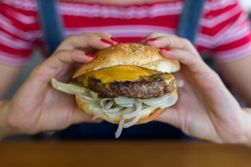 Close up view of woman's hands with burger