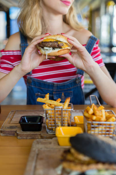 istock Young woman holding burger 1016491694