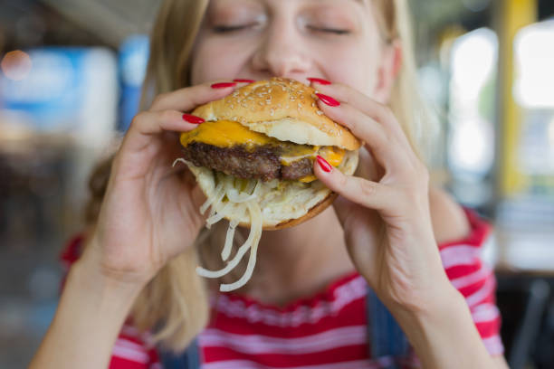 istock Woman eating beef burger 1016498260
