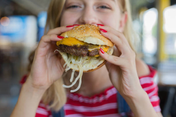 kvinna äta nötkött burger - cafe buns eating bildbanksfoton och bilder