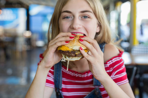 istock Woman eating burger 1016498336