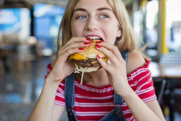 istock Woman eating burger 1016498436