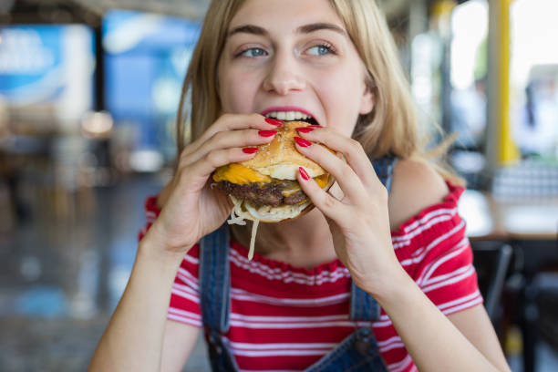 woman eating burger - burger hamburger large food imagens e fotografias de stock
