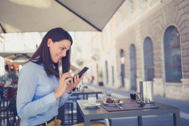 istock Young businesswomen enjoying coffee break at cafe, using mobile phone 1016498638