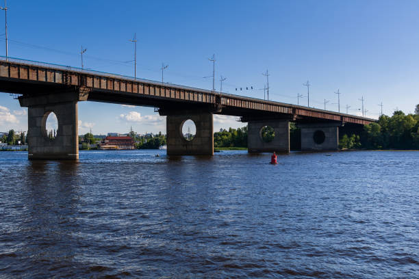 istock Bridge on a river against a blue sky and clouds 1016505232