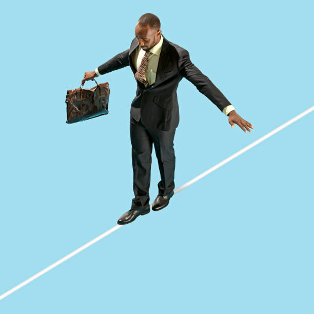 Business man on tightrope concentrate to walking isolated on blue background Business man on tightrope concentrate to walking isolated on blue background. Business, career, risk concepts tightrope stock pictures, royalty-free photos & images