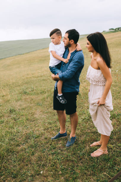 istock parents and son standing on green field 1016513792