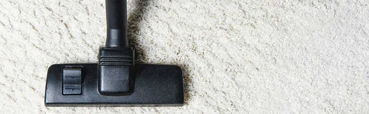 top view of white carpet and vacuum cleaner, close-up view