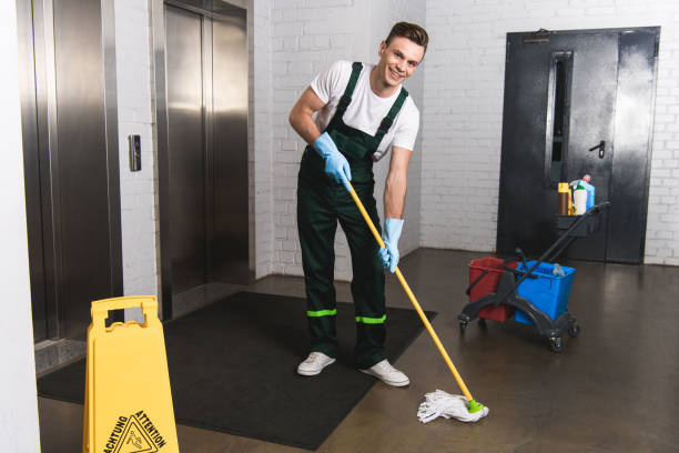 handsome young janitor mopping floor and smiling at camera handsome young janitor mopping floor and smiling at camera mop photos stock pictures, royalty-free photos & images