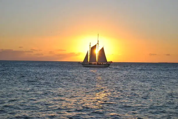 Beautiful image of sail boat crossing the water at just the right time.