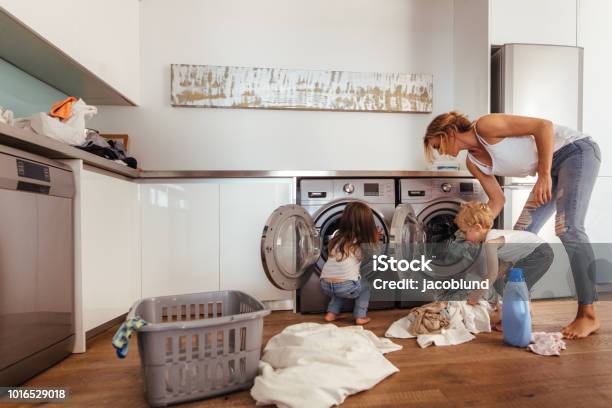 Family Doing Laundry Together At Home Stock Photo - Download Image Now - Family, Utility Room, Laundry