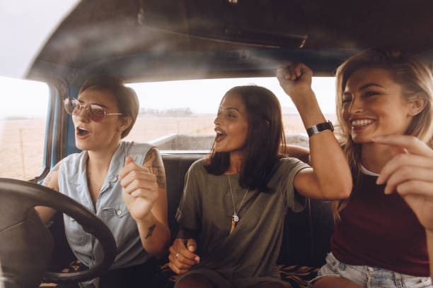 group of girls having fun in the car - image singing fun vacations imagens e fotografias de stock