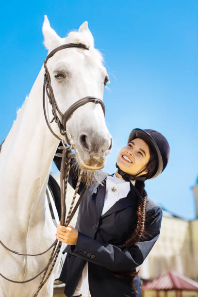 istock Dark-haired rider with long braid preparing for horse riding 1016537232