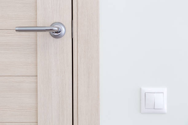 Interior detail. A door handle and a light switch stock photo