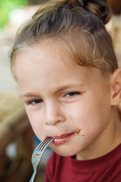 istock boy eating pancake with banana and chocolate 1016541190