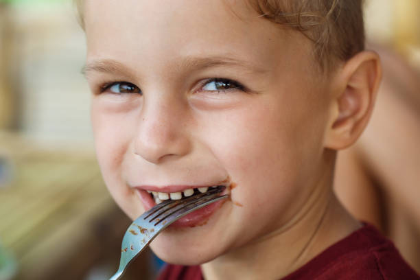 istock boy eating pancake with banana and chocolate 1016541358